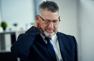 Buy stock photo Shot of a mature businessman experiencing neck ache at work in a modern office