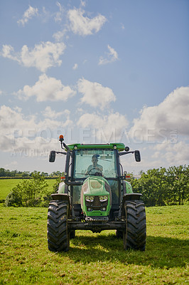 Buy stock photo Full length shot of a green tractor on an open piece of farmland