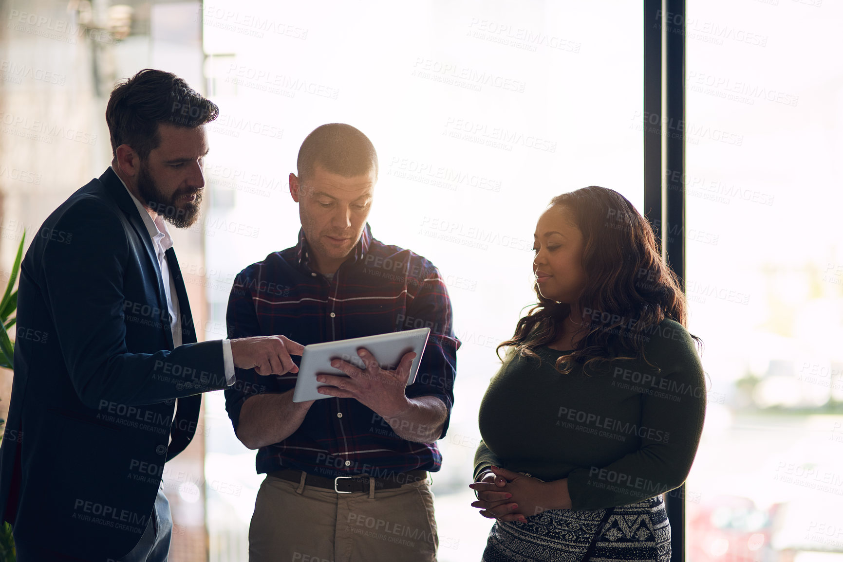 Buy stock photo Shot of a focused group of businesspeople having a discussion while using a digital laptop in a boardroom