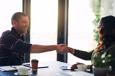 Buy stock photo Shot of two cheerful businesspeople shaking hands in agreement after a meeting in a boardroom