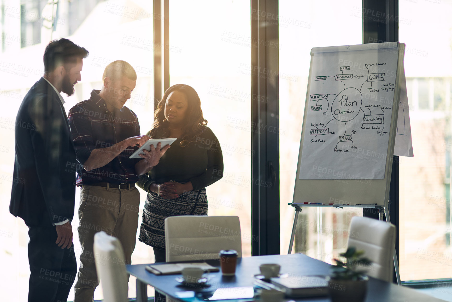 Buy stock photo Shot of a focused group of businesspeople having a discussion while using a digital laptop in a boardroom