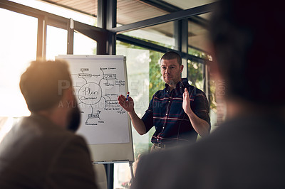 Buy stock photo Shot of a motivated businessman delivering a presentation to work colleagues in a boardroom