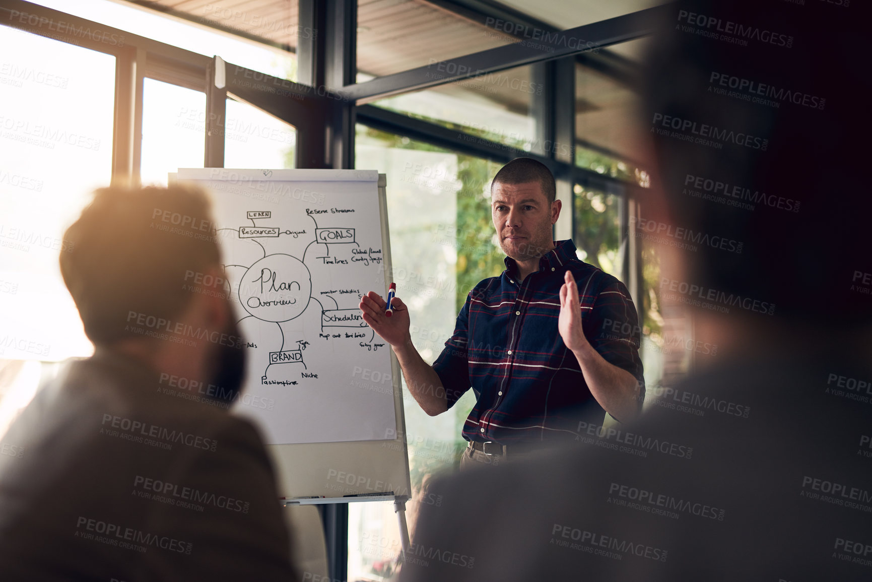 Buy stock photo Shot of a motivated businessman delivering a presentation to work colleagues in a boardroom