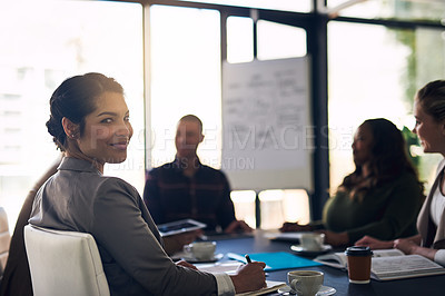 Buy stock photo Portrait of a confident business woman sitting in a boardroom meeting with work colleagues while looking into the camera