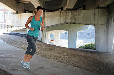 Buy stock photo Shot of an attractive young female runner exercising outdoors