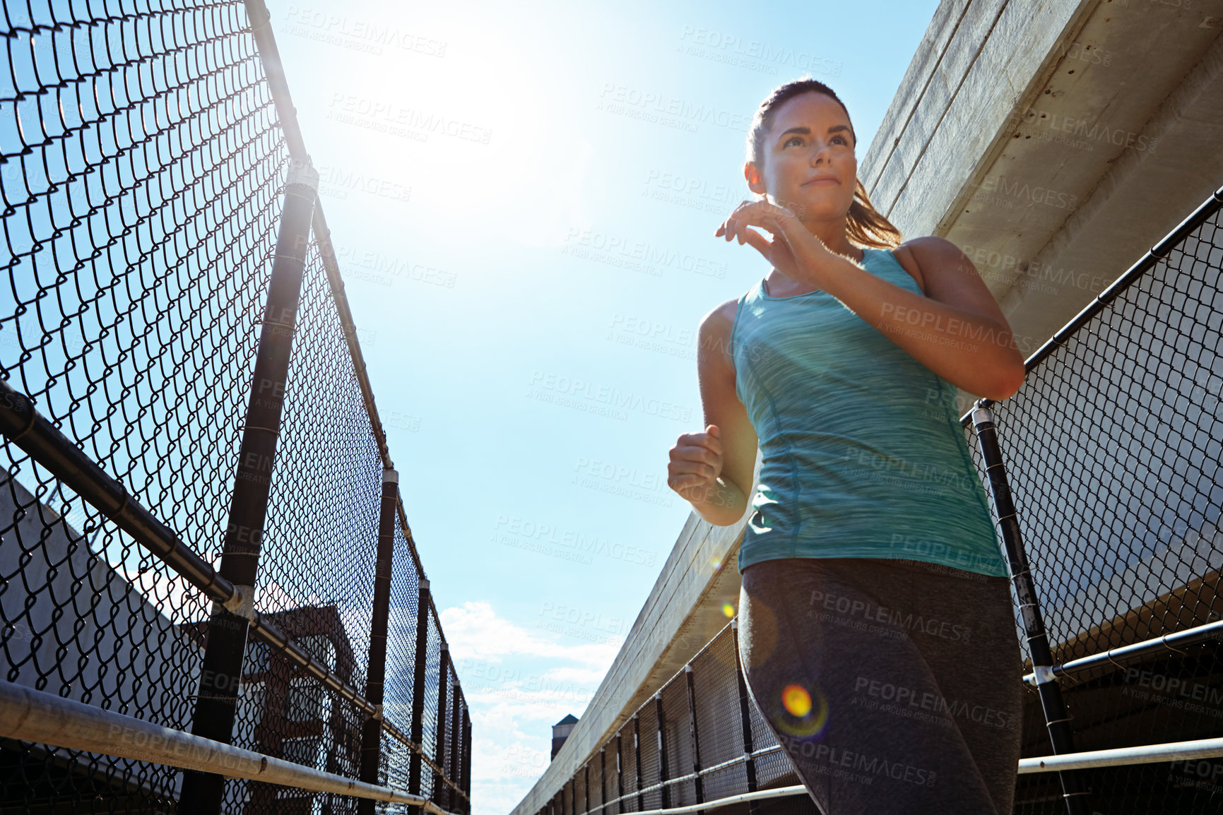 Buy stock photo Woman, run and low angle by fence for fitness, health or wellness with cardio workout for training. Person, runner or athlete with exercise outdoor, morning routine and practice with jog in the city