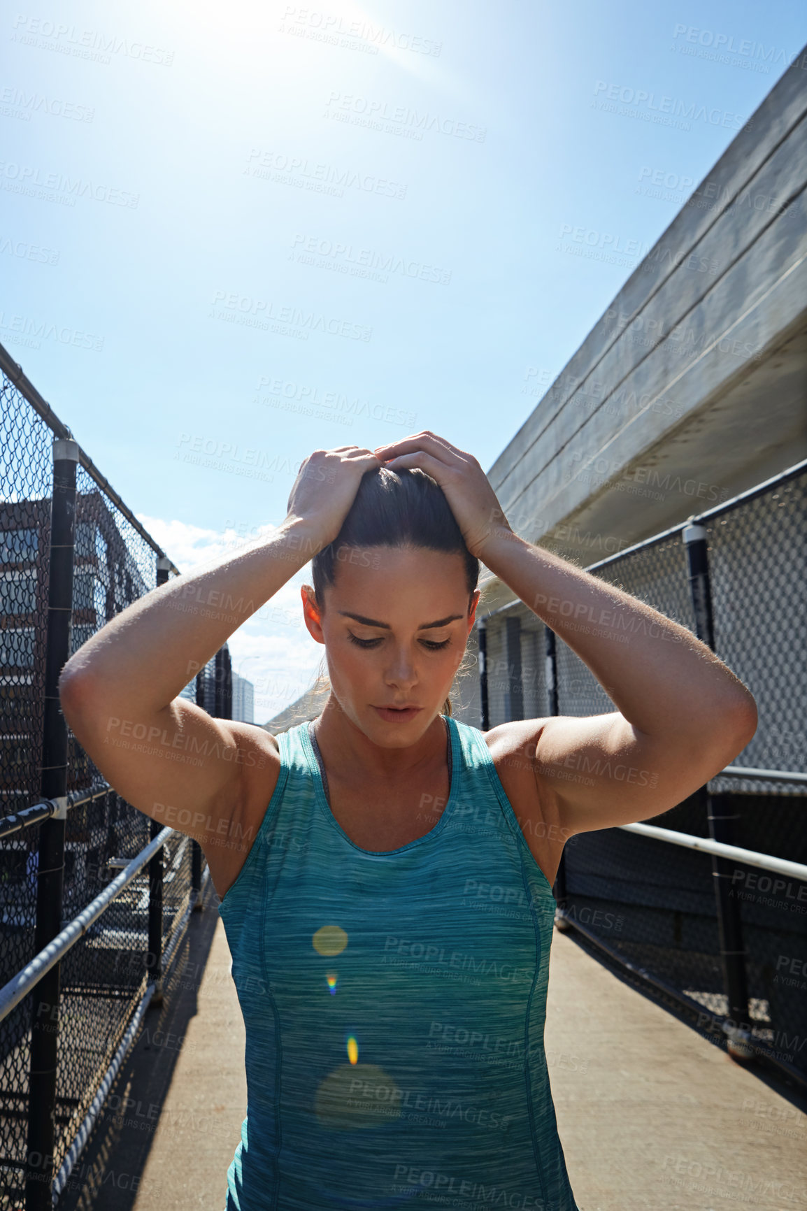 Buy stock photo Shot of a sporty young woman looking exhausted after her run