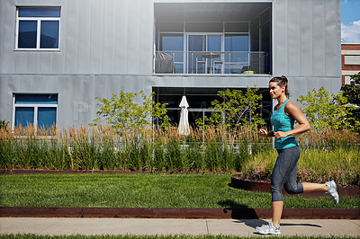 Buy stock photo Shot of an attractive young female runner exercising outdoors