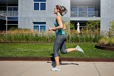 Buy stock photo Shot of an attractive young female runner exercising outdoors