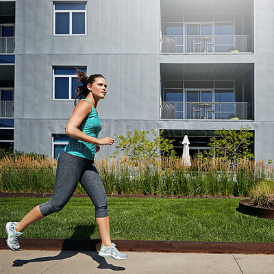 Buy stock photo Shot of an attractive young female runner exercising outdoors