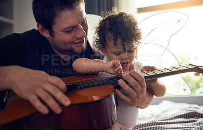 Buy stock photo Music, guitar and father playing with kid for learning, child development and bonding at home. Happy, artist and musician man teaching song on string instrument to baby in bedroom at family house.