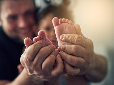 Buy stock photo Closeup shot of a man's hands holding his daughter's feet