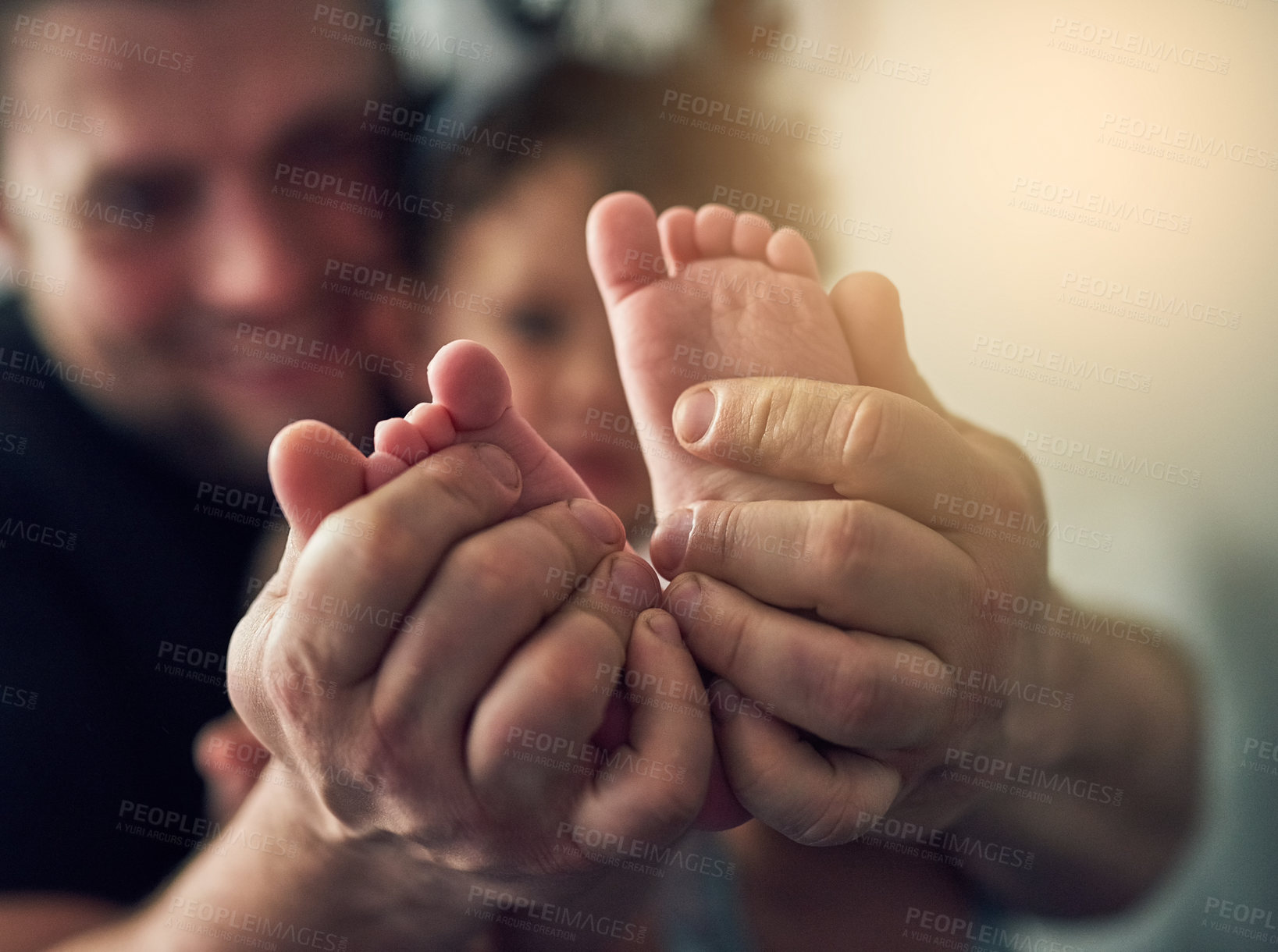 Buy stock photo Closeup shot of a man's hands holding his daughter's feet