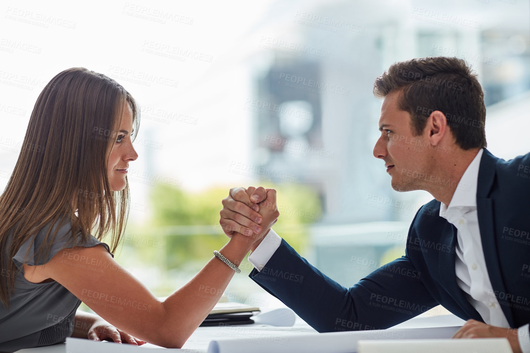 Buy stock photo Shot of two businesspeople arm wrestling in an office