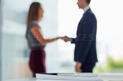Buy stock photo Cropped shot of two businesspeople shaking hands in an office