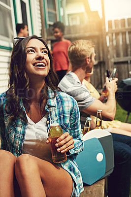 Buy stock photo Shot of a young woman enjoying a party with friends outdoors