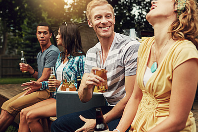 Buy stock photo Shot of a young man chatting to a friend at a party outdoors