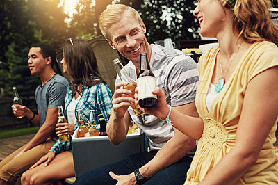 Buy stock photo Shot of a young man chatting to a friend at a party outdoors