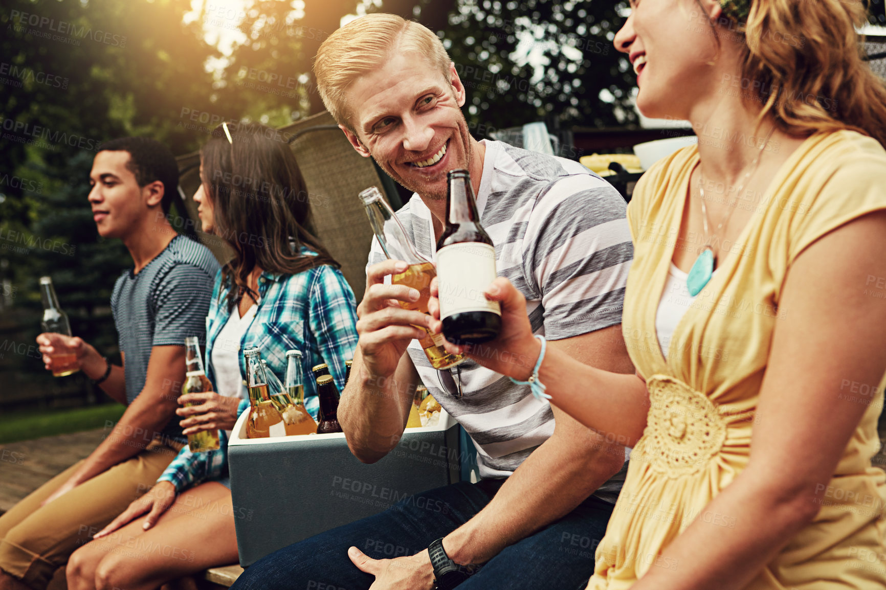 Buy stock photo Shot of a young man chatting to a friend at a party outdoors