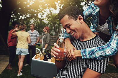 Buy stock photo Shot of a young couple enjoying a party with friends outdoors