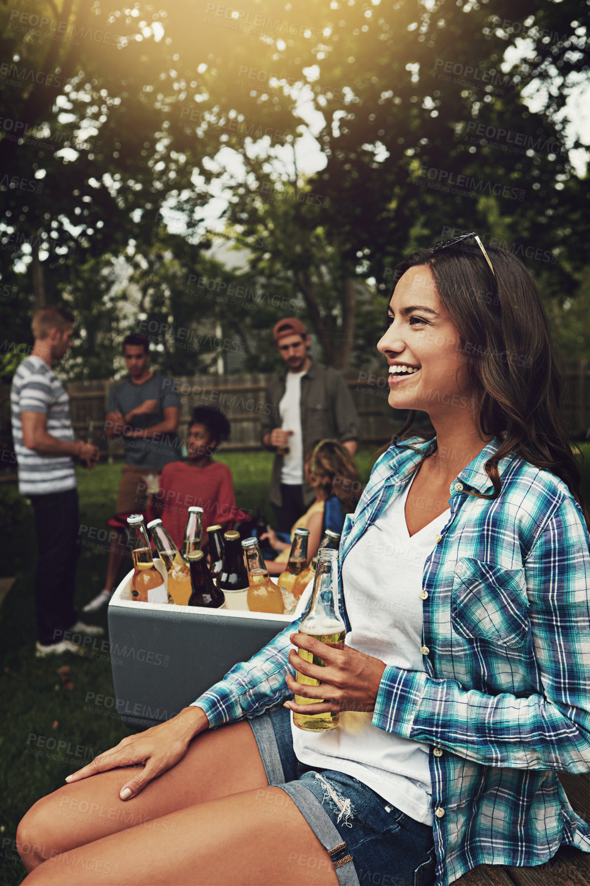 Buy stock photo Shot of a young woman enjoying a party with friends outdoors