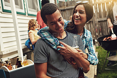 Buy stock photo Shot of a young couple enjoying a party with friends outdoors