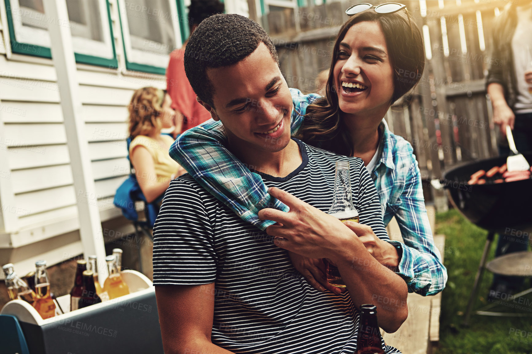 Buy stock photo Shot of a young couple enjoying a party with friends outdoors