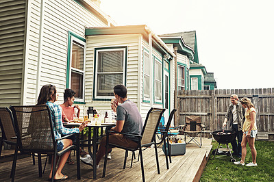 Buy stock photo Shot of a group of friends having a barbecue in the yard