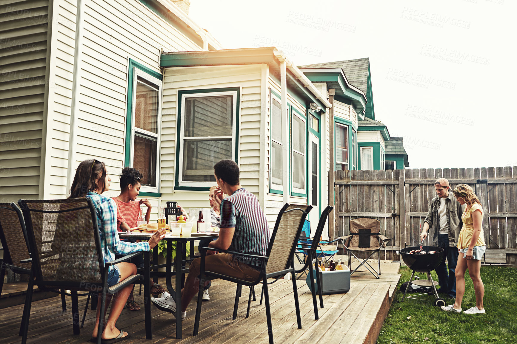 Buy stock photo Shot of a group of friends having a barbecue in the yard