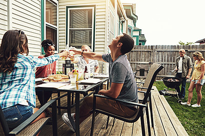 Buy stock photo Shot of a group of friends having a barbecue in the yard