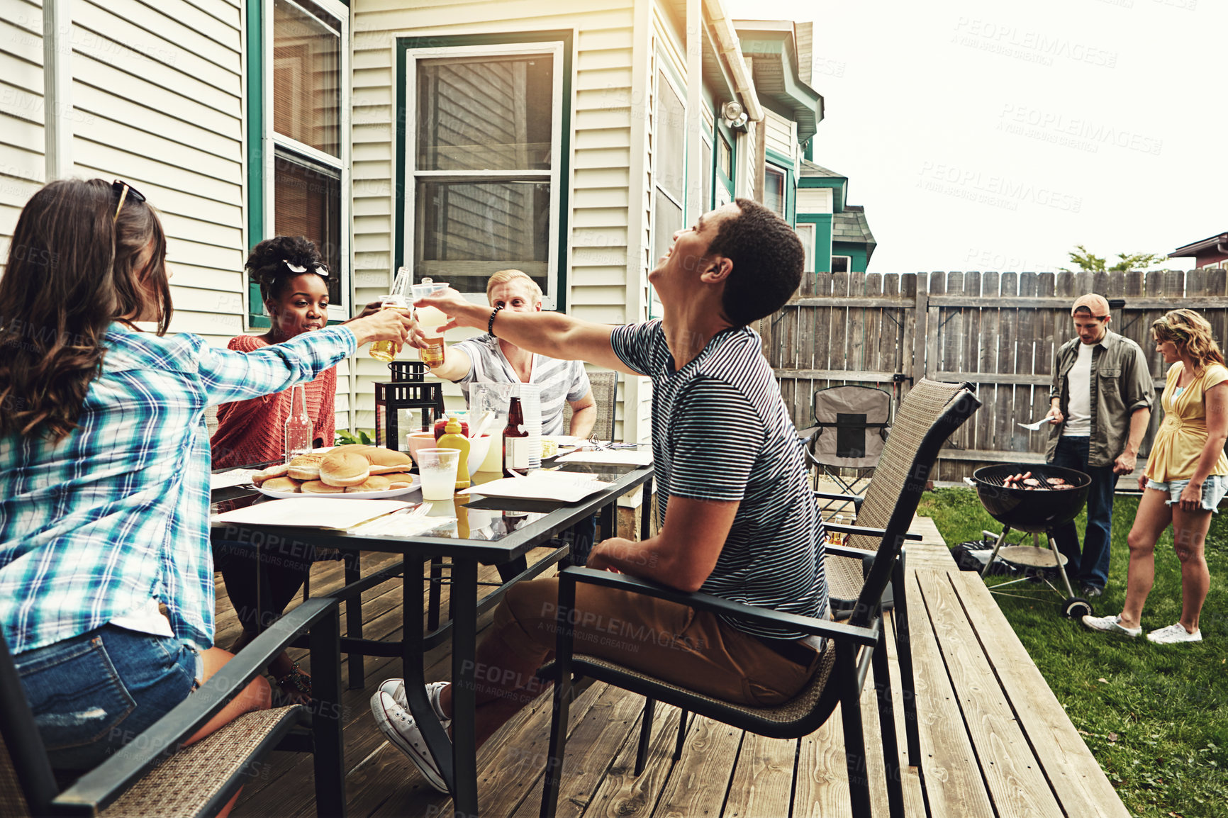 Buy stock photo Shot of a group of friends having a barbecue in the yard