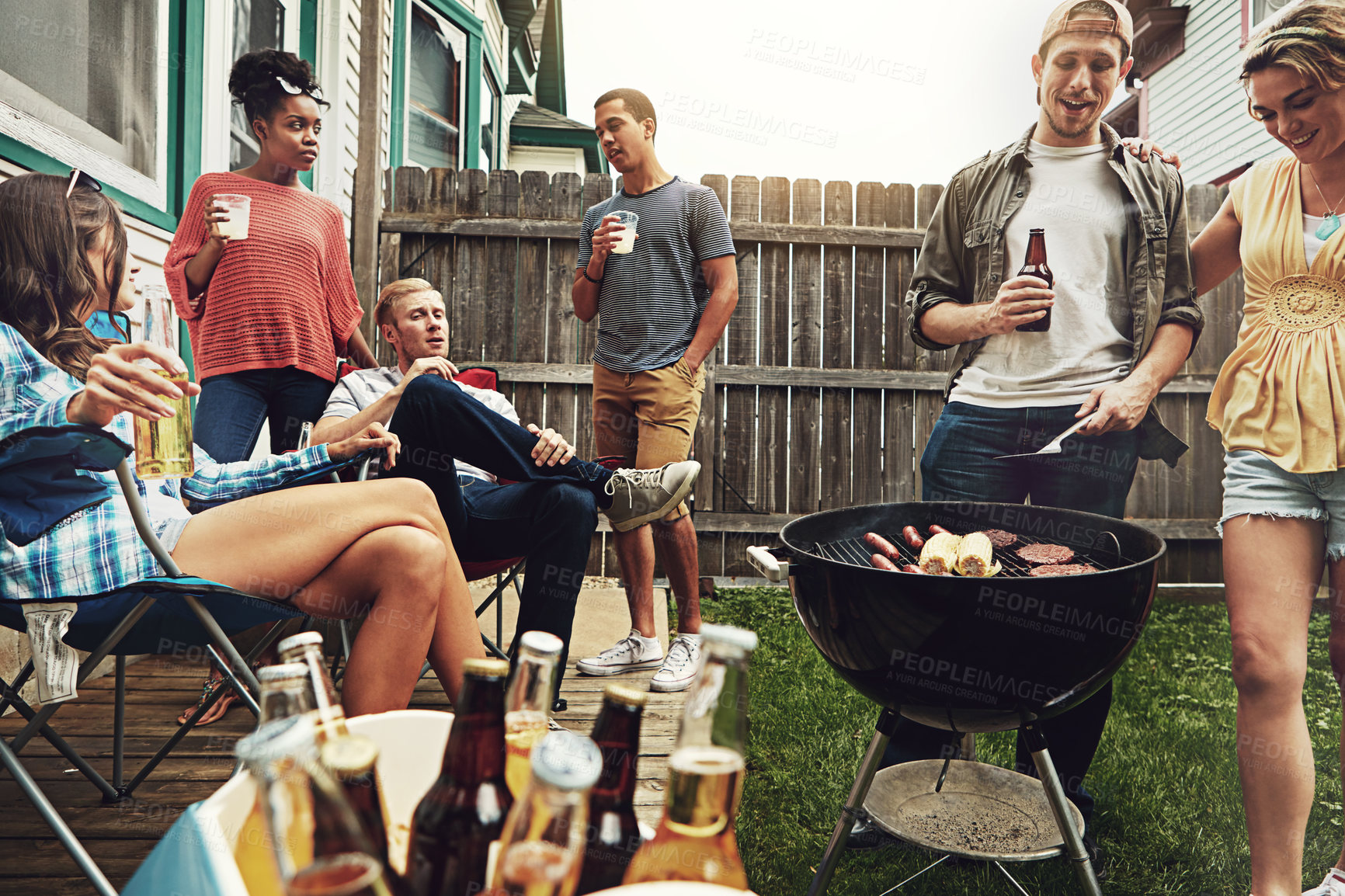 Buy stock photo Shot of a group of friends having a barbecue in the yard