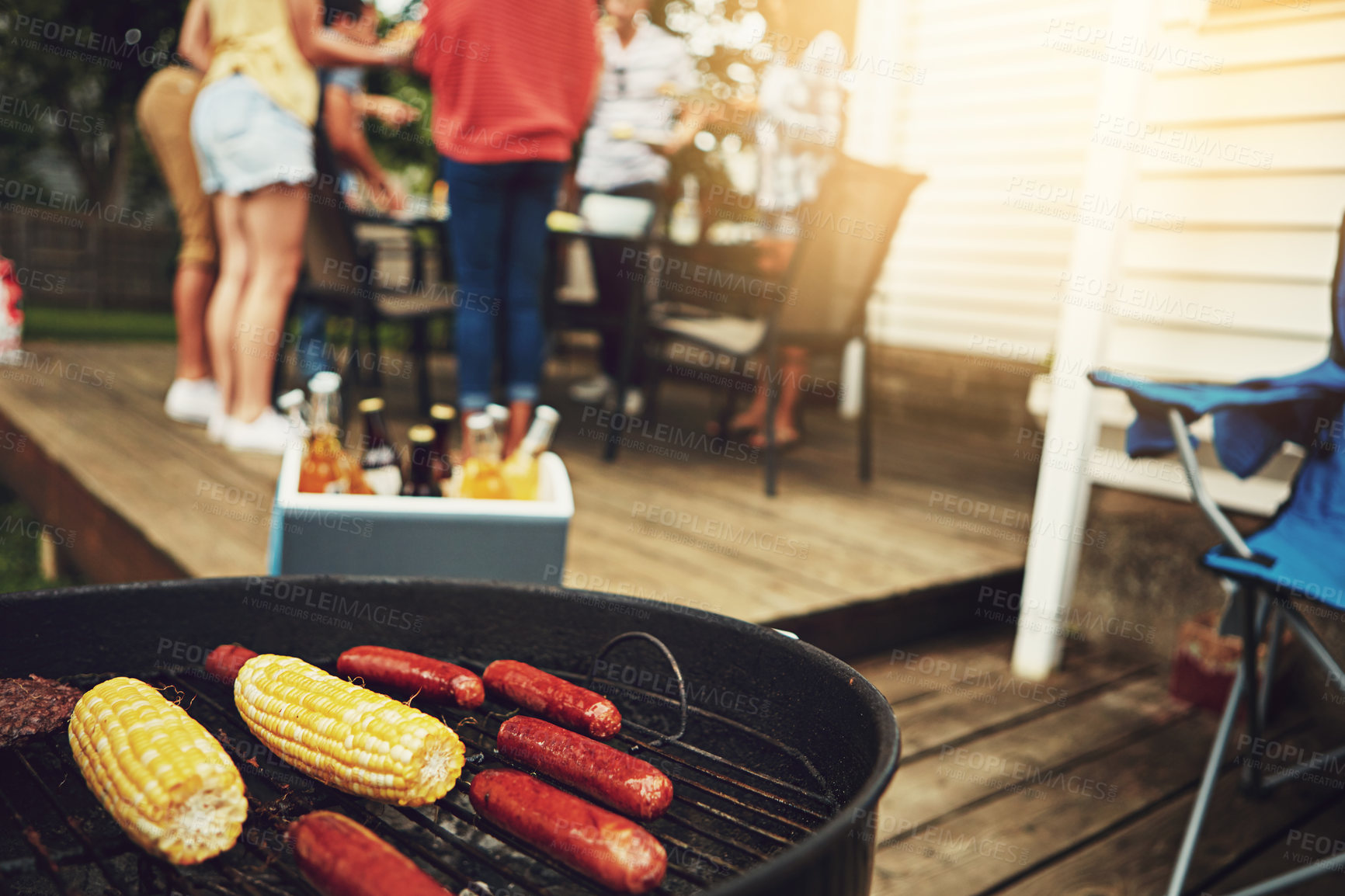 Buy stock photo Barbecue, food and outside on weekend with grill for corn, sausage and cooking on porch or backyard. Drinks, friends and dinner party with reunion, meal and summer in America with alcohol for people.