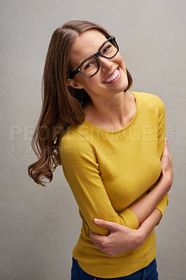 Buy stock photo Studio portrait of an attractive young woman standing with her arms folded against a grey background