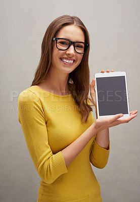 Buy stock photo Studio portrait of an attractive young woman posing with her tablet against a grey background