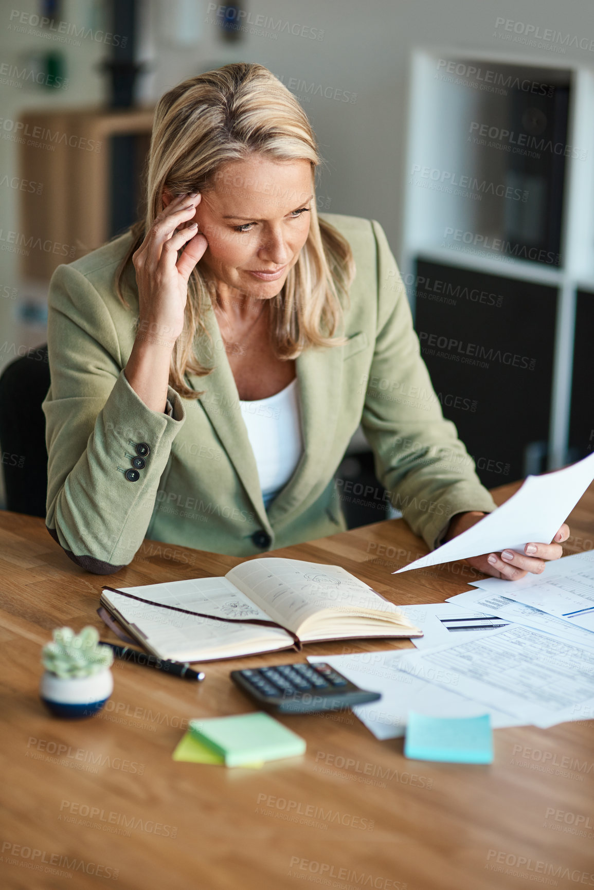 Buy stock photo High angle shot of a mature businesswoman looking thoughtful while working in her corporate office