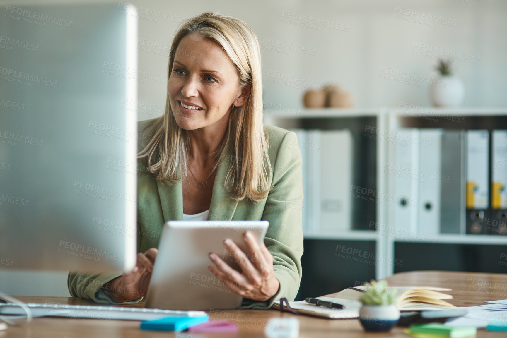 Buy stock photo Cropped shot of a mature businesswoman working on a tablet in her corporate office