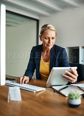 Buy stock photo Cropped shot of a mature businesswoman working on a tablet in her corporate office
