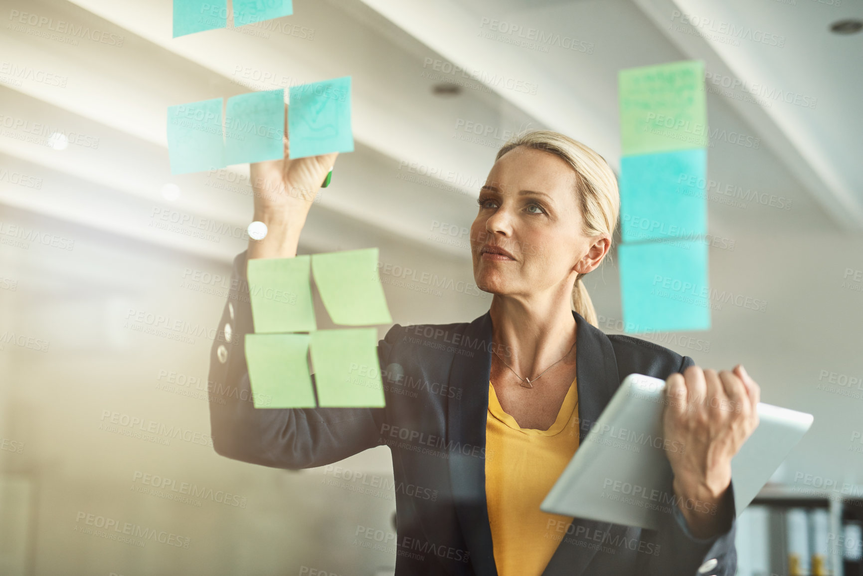 Buy stock photo Cropped shot of a mature corporate businesswoman planning on a glass wipe board