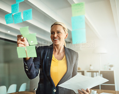 Buy stock photo Cropped shot of a mature corporate businesswoman planning on a glass wipe board