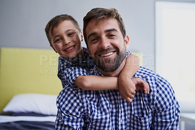 Buy stock photo Cropped portrait of a handsome young man and his son sitting in their home
