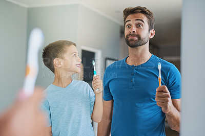 Buy stock photo Funny face, brushing teeth and father with son in bathroom mirror for morning routine, comic and dental. Oral hygiene, cleaning and smile with man and child in family home for self care and wellness