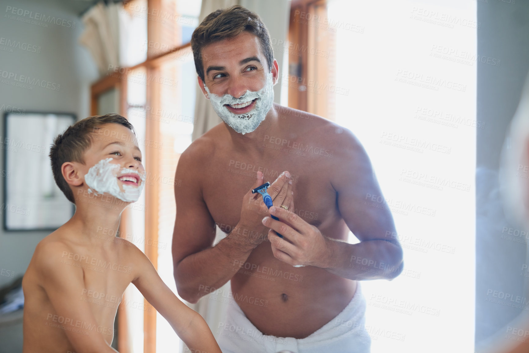 Buy stock photo Cropped shot of a handsome young man teaching his son how to shave in the bathroom