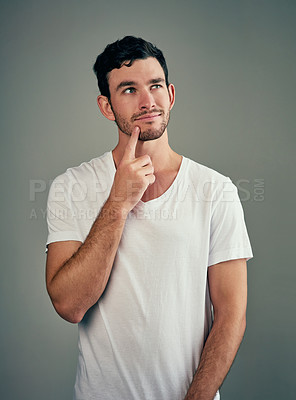 Buy stock photo Man, ideas and decision in studio with tshirt or memory and inspiration for positive mindset. Male person, vision and thinking or review with mindfulness, smile or choice by gray background  