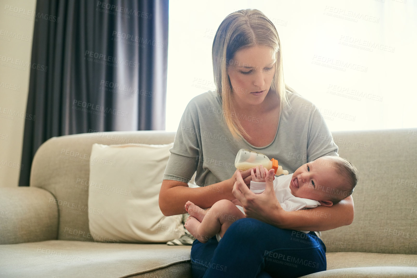 Buy stock photo Mother, milk bottle and feed baby on sofa in living room for growth development, nutrition or digestive health. Love, formula and woman with infant child for drinking, wellness or bonding in home