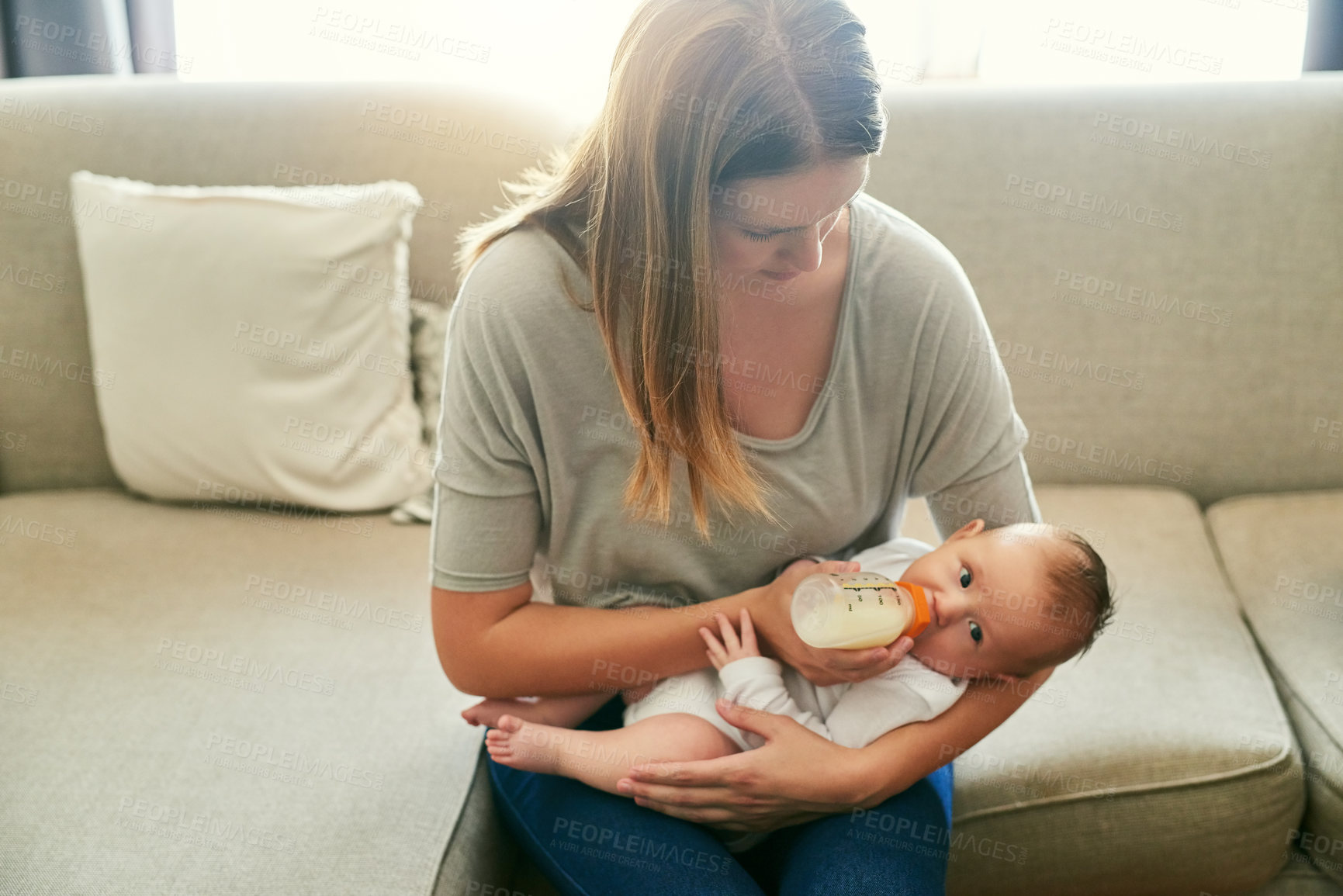 Buy stock photo Sofa, mother and baby drinking milk in living room for growth development, nutrition or health. Formula, woman parent and infant child with bottle for feeding, wellness or bonding with love in home