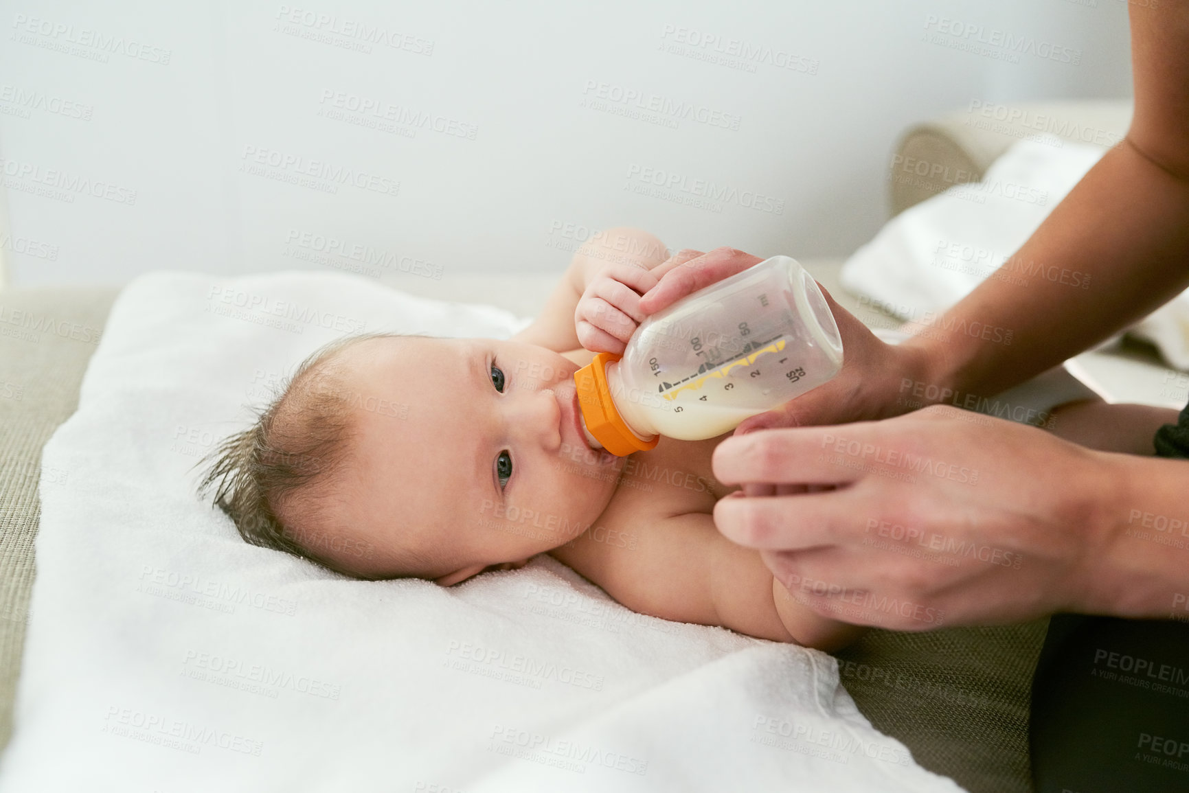 Buy stock photo Hands of mother milk and feeding baby on sofa for growth development, nutrition or health. Drinking, woman parent and infant child with bottle for formula, wellness or bonding with love in home
