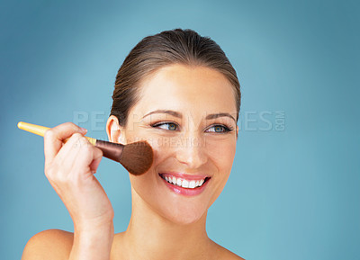 Buy stock photo Woman, brush and makeup in studio for skincare, beauty and spa treatment on blue background. Girl, happy and foundation application with healthy skin, smile and aesthetic with facial transformation