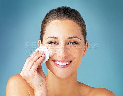 Buy stock photo Dermatology, portrait and happy woman with cotton pad on face, skincare and makeup cleaning product. Cosmetics, skin care and wellness for model with beauty, detox and facial glow on blue background.
