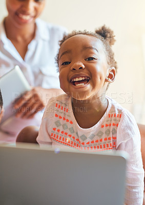 Buy stock photo Cropped portrait of an adorable little girl laughing while playing on a laptop at home